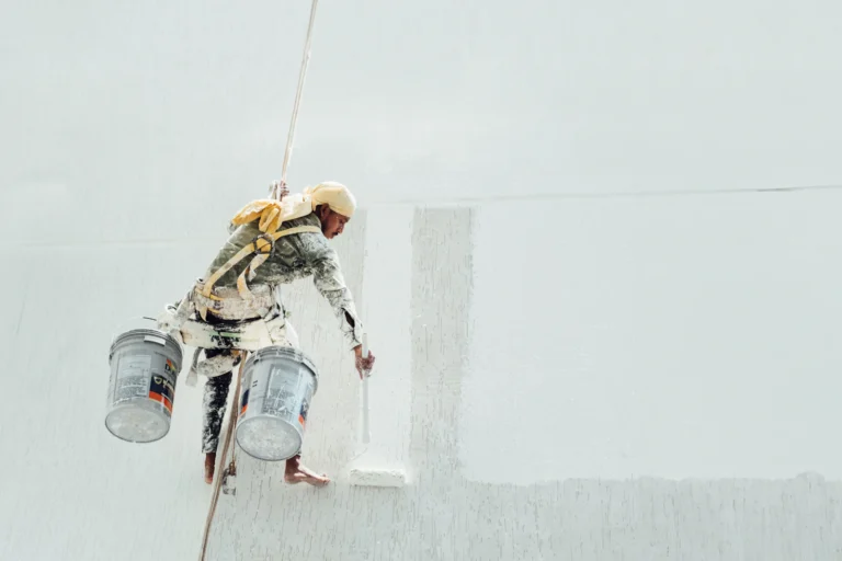 Painter applying white paint to an interior wall