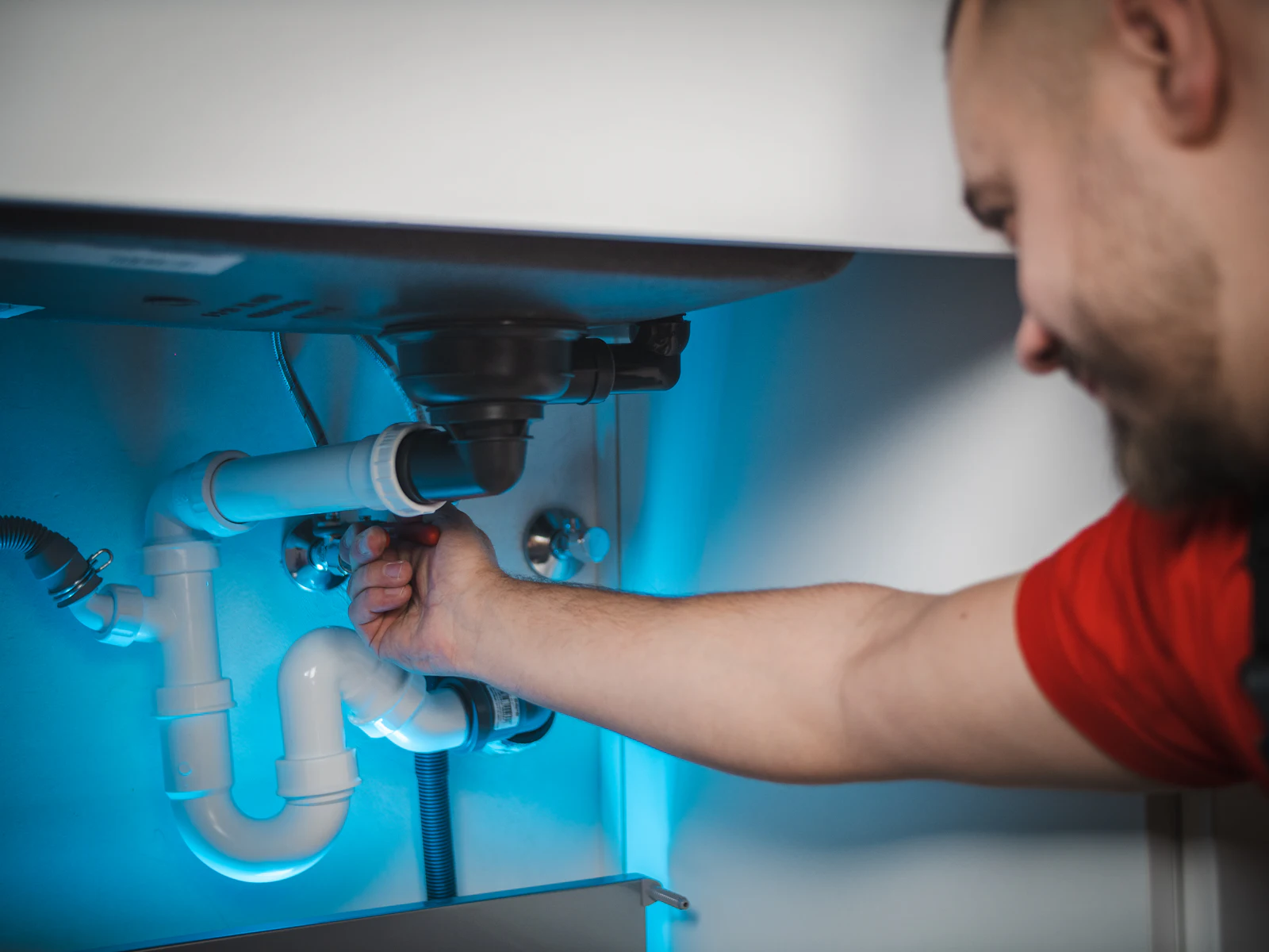 Plumbing work on pipes inside a wall