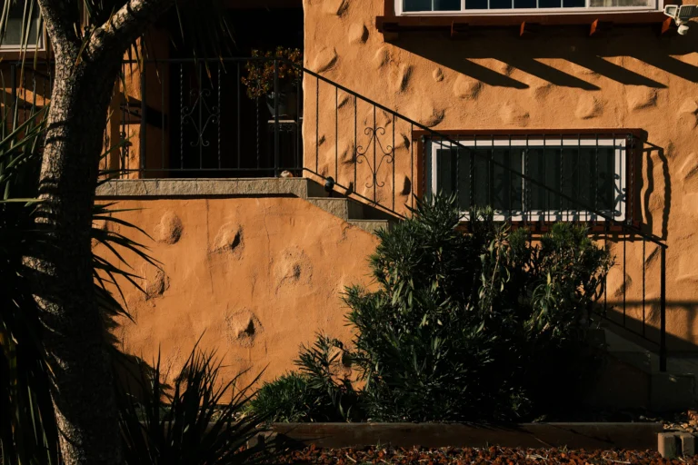 Stucco home exterior with stairs and plants