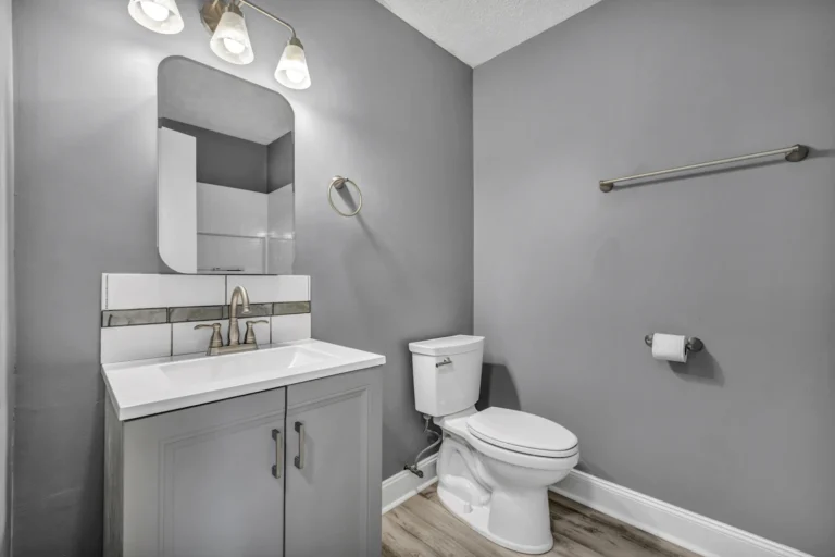Bathroom with tiled floor, grey walls and a white vanity