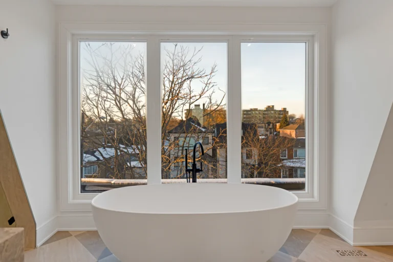 Tiled bathroom with a freestanding tub and large window